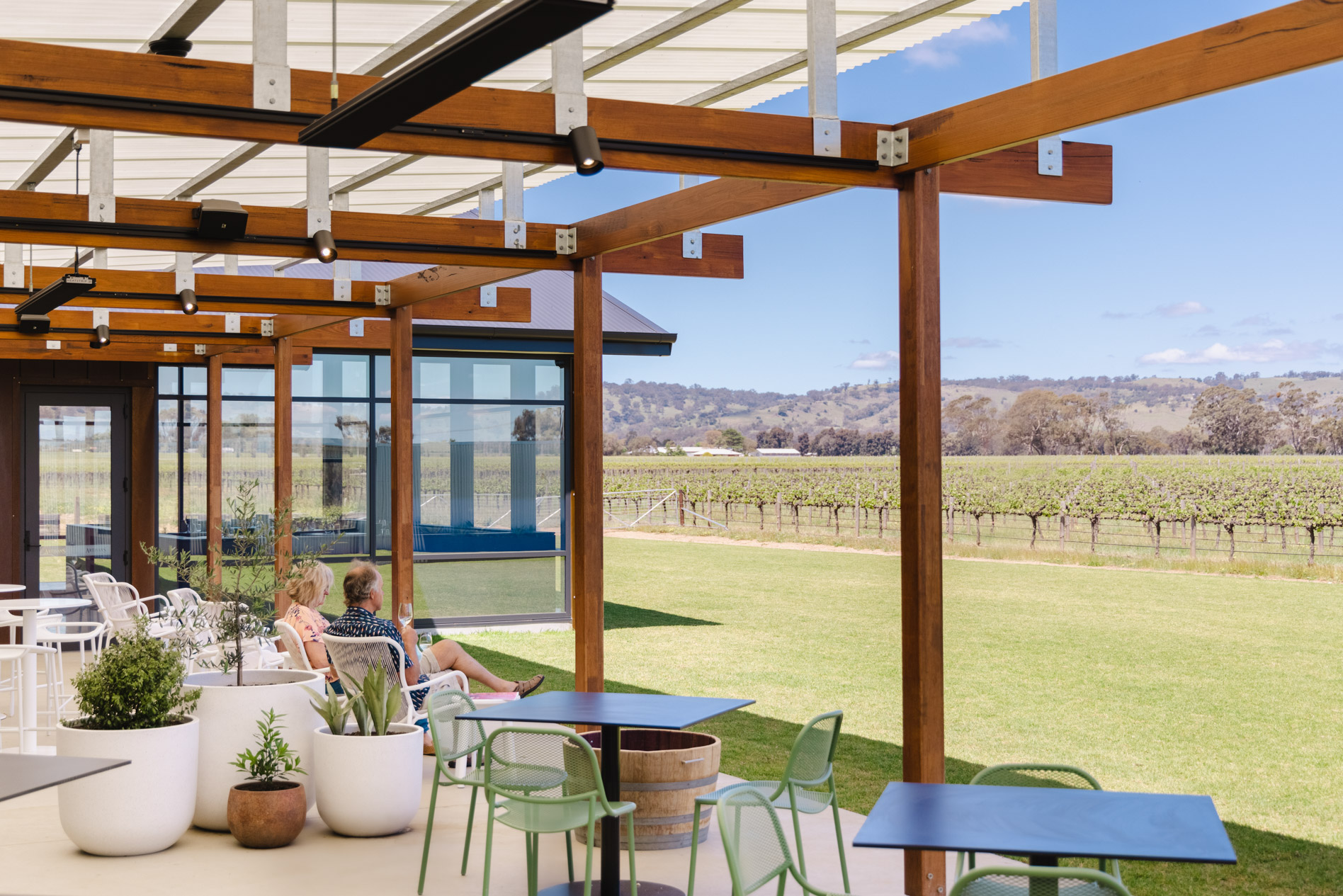 Terrace with man and woman sitting looking at vineyard